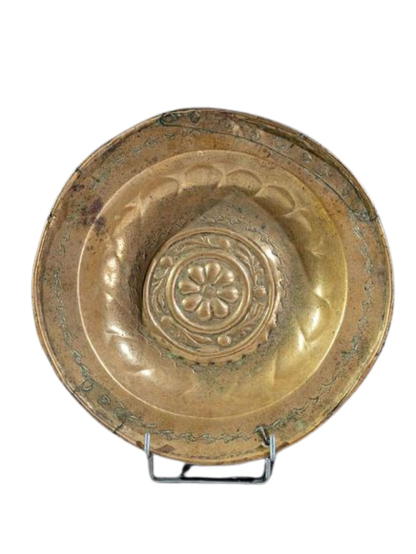 Antique brass plate with a central floral or geometric motif, displayed on a stand.