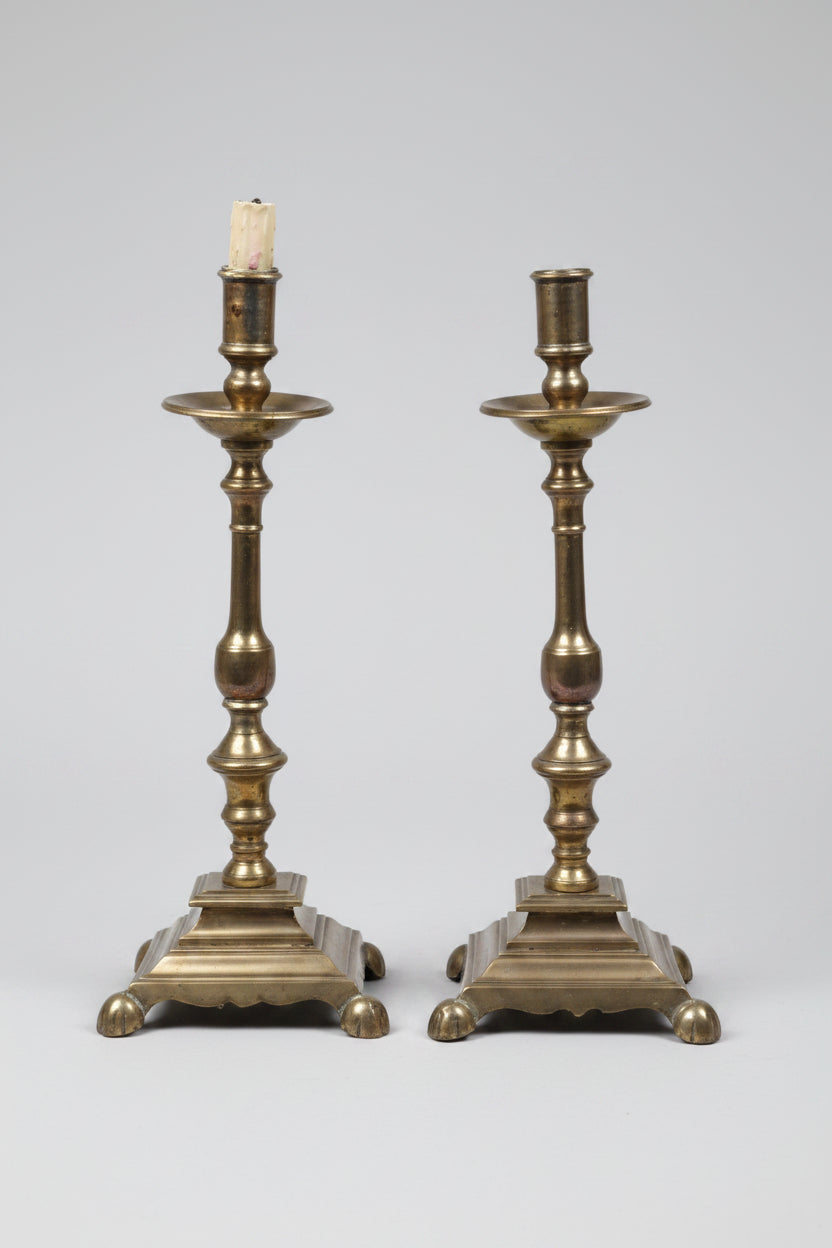 Pair of brass candlesticks on a white background