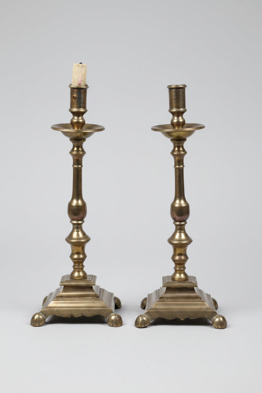 Pair of brass candlesticks on a white background