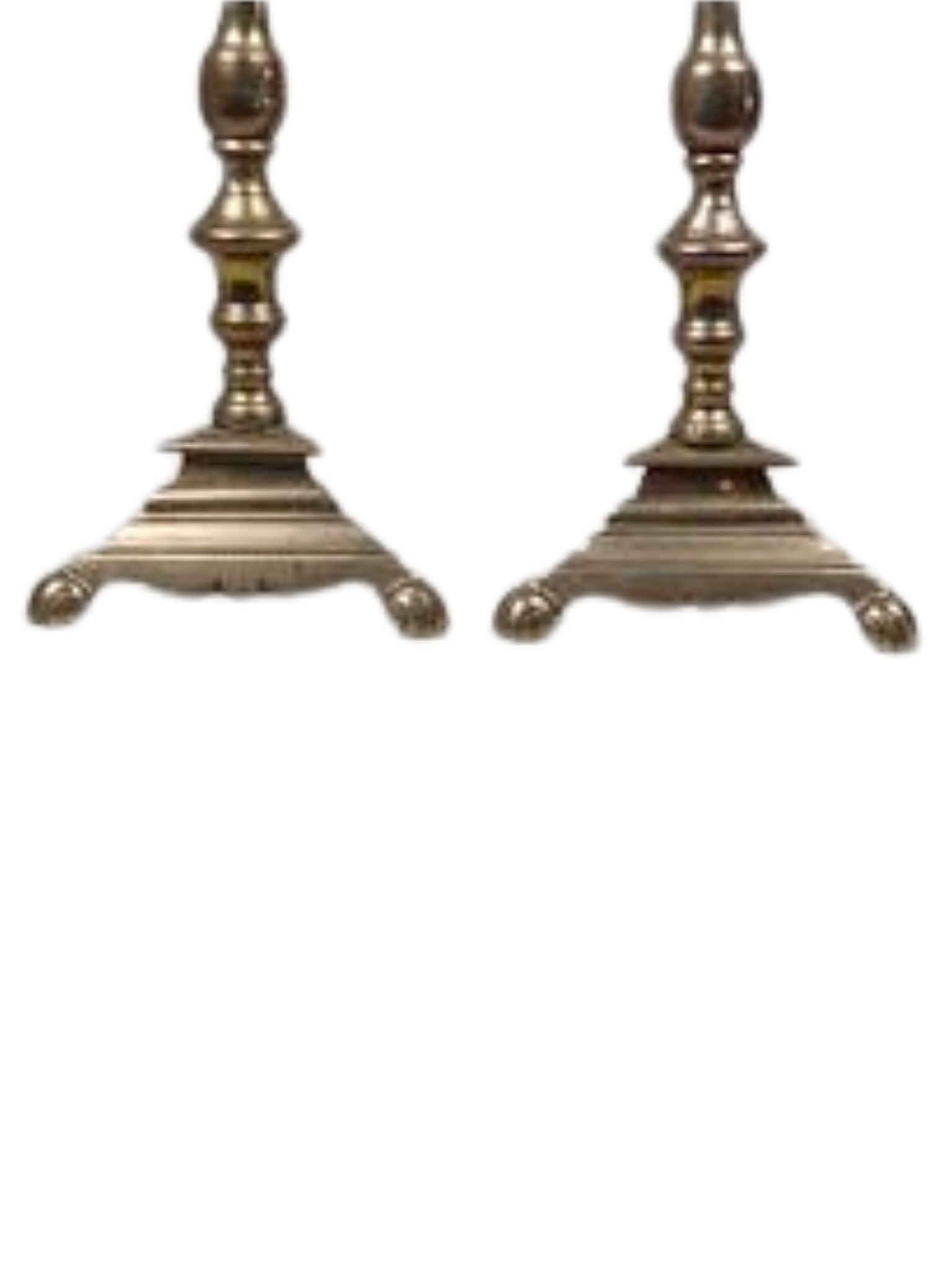 Two ornate brass candle holders on a white background