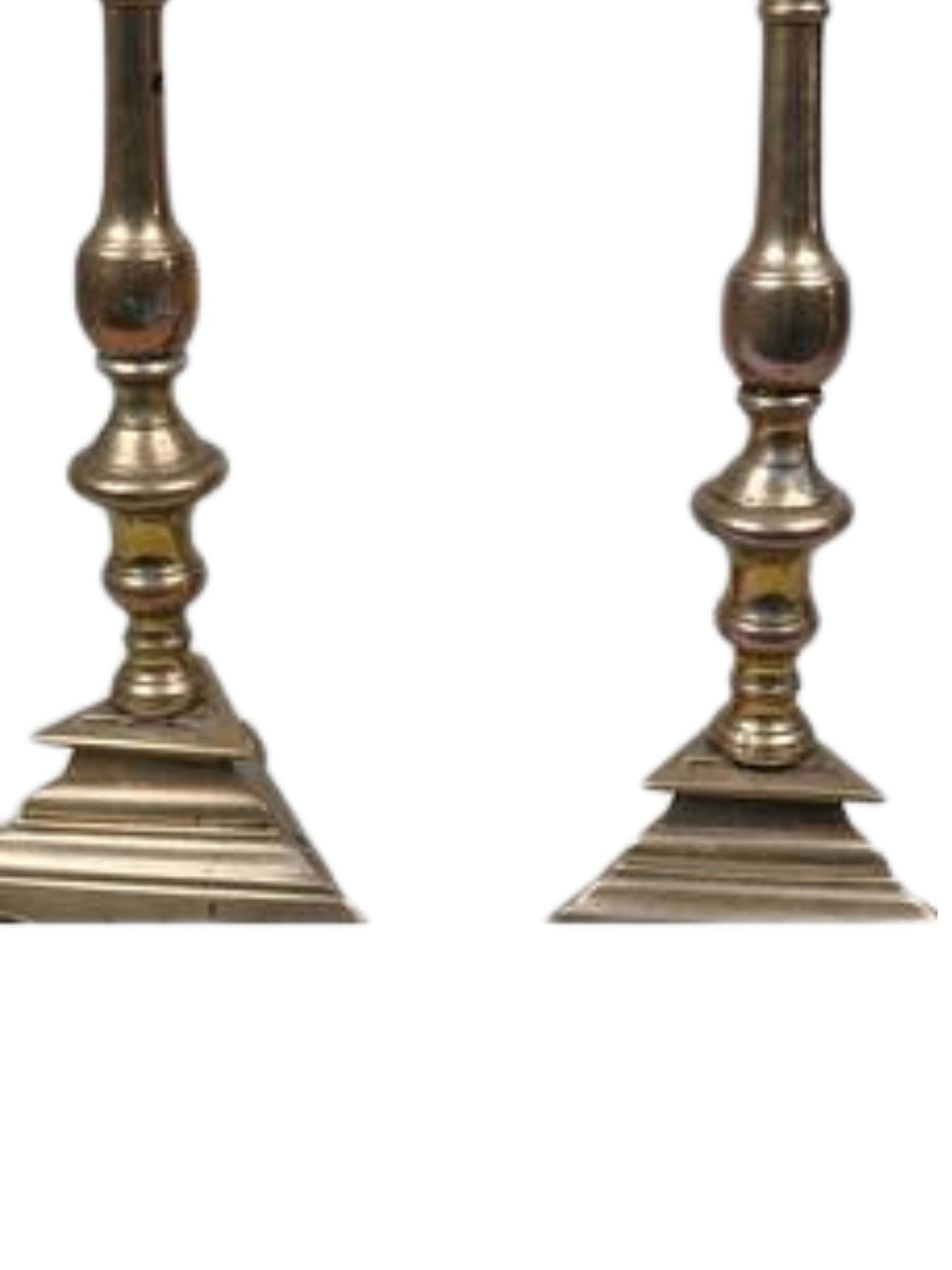 Pair of ornate brass candlesticks on a white background