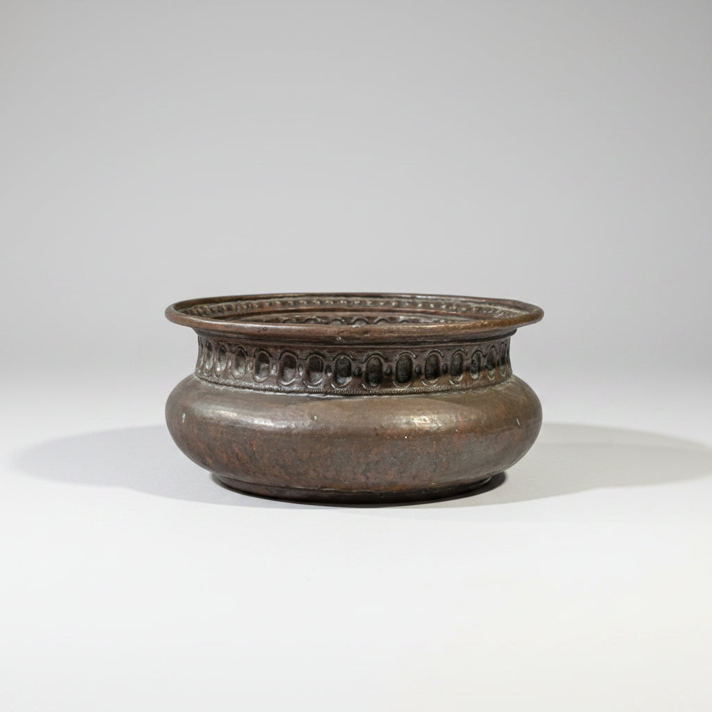 A 17th century copper basin with a baluster body, decorated with mouldings of pearls and ovals.